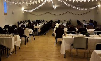 a large dining room with multiple tables and chairs arranged for a group of people to enjoy a meal together at Holt Inn