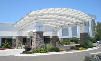 a large white structure with a stone base and arches is surrounded by plants and flowers at Holiday Inn Grand Haven - Muskegon