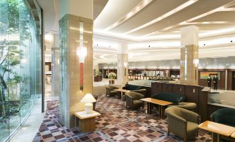 a hotel lobby with a large reception desk , multiple chairs , and a coffee table in the center at Hotel Nikko Kansai Airport