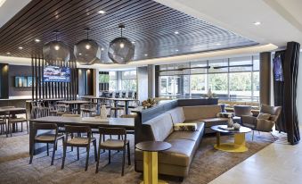 a modern hotel lobby with a bar , couches , and chairs , creating a comfortable and inviting atmosphere at SpringHill Suites Columbia