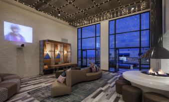 a modern hotel lobby with a seating area , large windows , and a view of the ocean at Hotel Hermosa