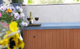 a wooden deck with a bottle of wine and two glasses of wine on a table at Taylor Edes Inn