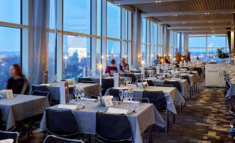 a large dining room with multiple tables and chairs arranged for a group of people at Gothia Towers & Upper House