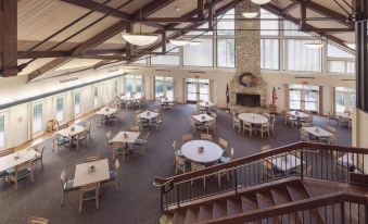 a large dining room with multiple tables and chairs , a fireplace , and a fireplace in the background at Dale Hollow Lake State Resort Park