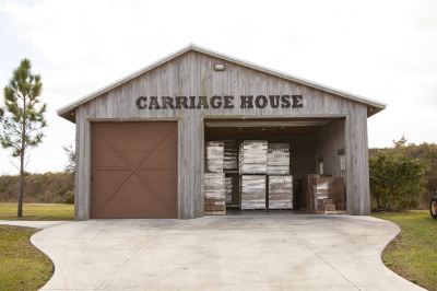 "a wooden garage with a sign that reads "" carriage house "" and several boxes of supplies stored in the garage" at OK Corral OK Corral Photo