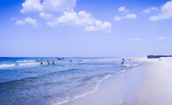 a group of people are playing in the ocean near a beach , with boats nearby at Sepon Boutique Resort