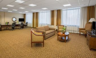 a large , well - lit hotel lobby with multiple chairs and couches arranged for guests to relax at Crowne Plaza Cleveland Airport