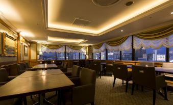 a well - lit dining room with several tables and chairs , creating an inviting atmosphere for guests at Kawasaki Nikko Hotel