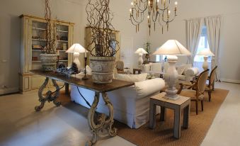 a living room with a large wooden table in the center , surrounded by various pieces of furniture such as a couch , chairs , and a coffee at Castello Camemi