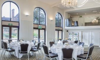 a large , elegant dining room with multiple round tables and chairs arranged for a formal event at New Place