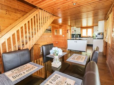 a dining room with wooden walls , a wooden floor , and a staircase leading to the second floor at Moon Face