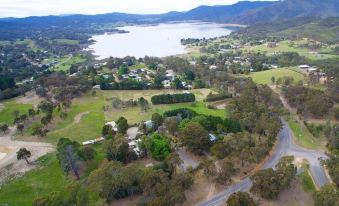 a bird 's eye view of a forested area with a lake and mountains in the background at Fernleigh Accommodation