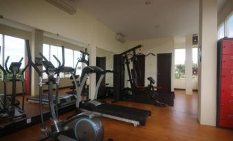 a well - equipped gym with various exercise equipment , including treadmills and weight machines , positioned in a spacious room with large windows at Valdos Hotel Manokwari