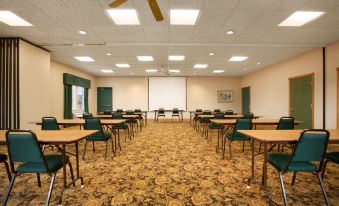a large conference room with rows of chairs and tables , a projector screen , and ceiling fans at Country Inn & Suites by Radisson, Kalamazoo, MI