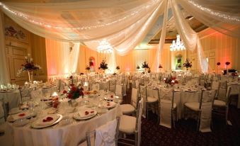 a beautifully decorated banquet hall with multiple dining tables covered in white tablecloths and adorned with flowers at The Saint Paul Hotel