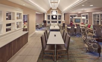 a modern hotel lobby with various seating options , including chairs and couches , as well as a dining table at Residence Inn Hartford Avon