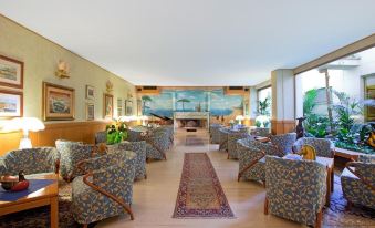 a spacious living room with multiple couches and chairs arranged in a circle , creating a cozy and inviting atmosphere at Hotel L'Approdo