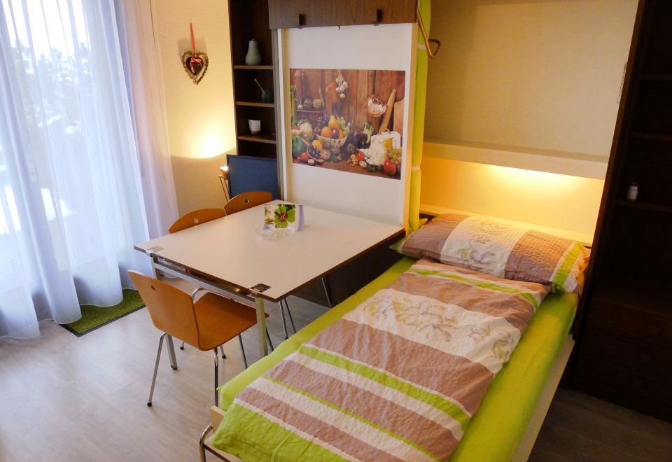 a small , cozy bedroom with a bed , table , and chair in the corner of the room at Annex