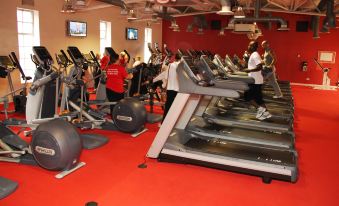 a large gym with people working out on treadmills and stationary bikes , creating a fitness center atmosphere at Lansdowne Hotel