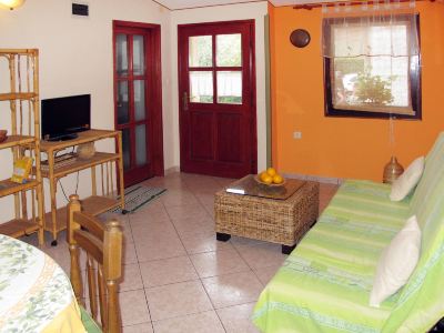 a small living room with a couch , a television , and a dining table in the background at Ingrid