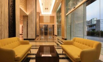 a modern , well - lit lobby with two yellow couches and a glass partition , creating an inviting atmosphere for guests at Hompton Hotel by The Beach