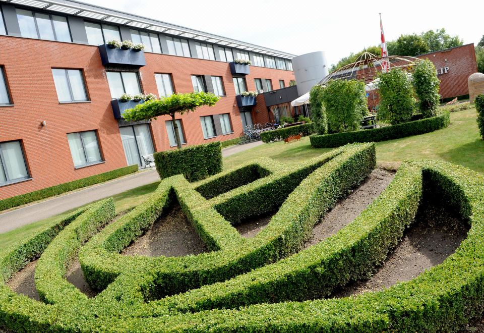 "a brick building with a sign that reads "" hotel "" in the courtyard of a hotel" at Fletcher Hotel-Restaurant Zevenbergen-Moerdijk