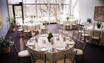 a large dining room set up for a formal event , with several tables and chairs arranged for guests at Inn at Villanova University