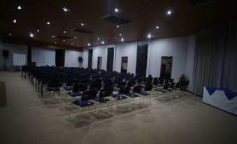 a large conference room with rows of chairs arranged in a semicircle , ready for an event at Desert Cave Hotel