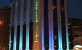 a tall building with blue and green lights illuminating it at night , creating a vibrant atmosphere at Prestige Hotel