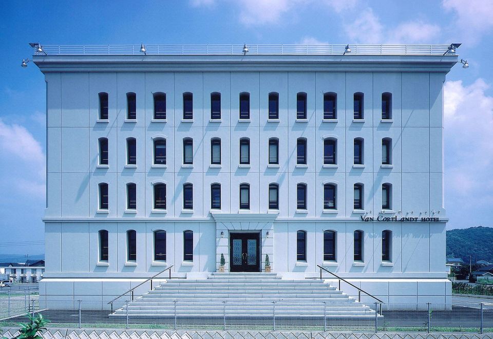 "a large white building with many windows and a sign that says "" lake qualifiers "" in the background" at Van Cortlandt Hotel