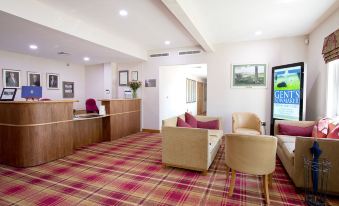 a hotel lobby with various seating options , including couches and chairs , as well as a reception desk at Sandford Springs Hotel and Golf Club