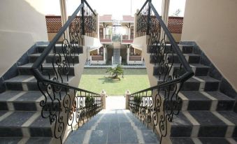 a grand staircase with black wrought iron railings , leading up to a grassy courtyard with a garden and buildings at Hotel Westwood
