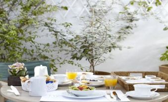 a dining table set for breakfast , with a variety of dishes and utensils arranged on the table at Hydra Hotel