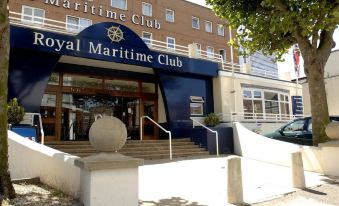 the entrance to the royal maritime club with its sign and the name displayed in white letters at Royal Maritime Hotel