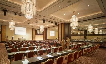 a large conference room with multiple rows of chairs arranged in a semicircle , providing seating for a large group of people at PARKROYAL Penang Resort