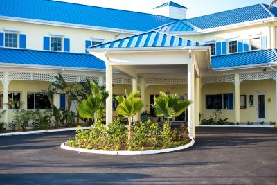 a blue and white building with a parking lot in front of it , surrounded by trees at Wyndham Reef Resort Grand Cayman