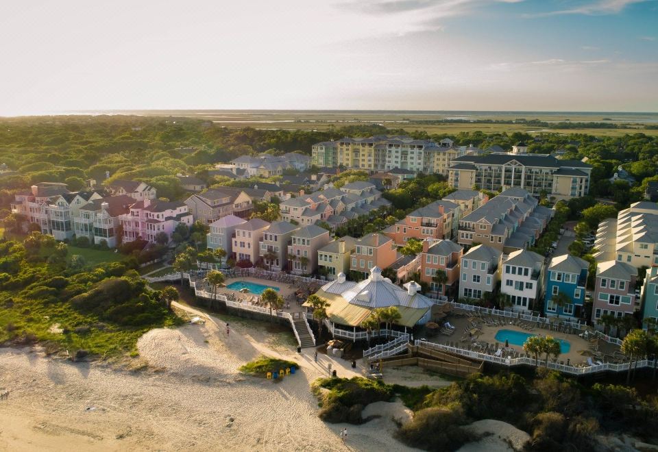 an aerial view of a beach town with multiple buildings , swimming pools , and a sandy beach at Wild Dunes Resort