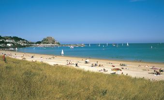 a beach scene with a group of people enjoying their time on the sand and in the water at Beachcombers Hotel