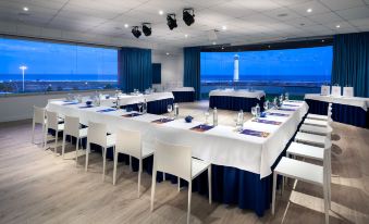 a conference room set up for a meeting , with tables and chairs arranged in rows at Mur Faro Jandia Fuerteventura & Spa