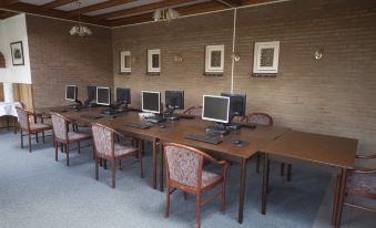 a room with multiple computer stations , each equipped with a computer monitor , keyboard , and mouse at Fletcher Hotel Restaurant de Gelderse Poort