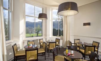 a well - lit dining room with tables and chairs arranged for a group of people to enjoy a meal at The Tarbet Hotel