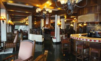 a large dining room with wooden tables and chairs , a fireplace , and a chandelier hanging from the ceiling at Ngorongoro Serena Safari Lodge