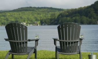 a man and a woman are sitting on lawn chairs near a body of water , enjoying each other 's company at Lake Bomoseen Lodge