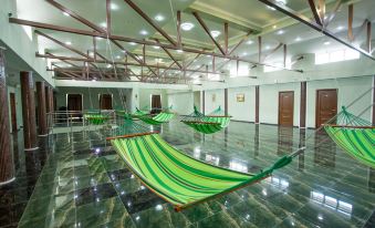 a large room with several hammocks hanging from the ceiling , creating a unique and unconventional space at Well Hotel