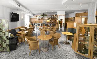 a modern cafe with wooden furniture , black leather seating , and a tv on the wall at Fairway Hotel