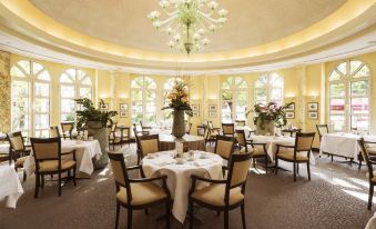a large , elegant dining room with multiple tables and chairs arranged for a formal event at Hotel Nassauer Hof