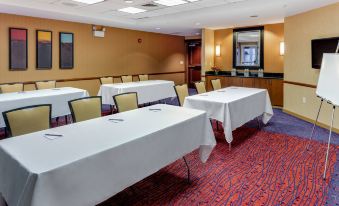 a conference room set up for a meeting , with several tables and chairs arranged in rows at Residence Inn Auburn