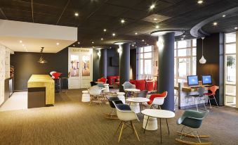 a modern lounge area with various seating options , including couches and chairs , in a comfortable environment at Ibis London Greenwich