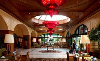 a grand hotel lobby with a large red chandelier hanging from the ceiling , creating an elegant atmosphere at Divan Istanbul