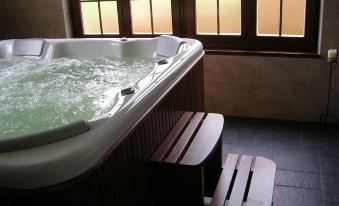 a hot tub with wooden benches and a bench for bathing in front of a window at El Castro